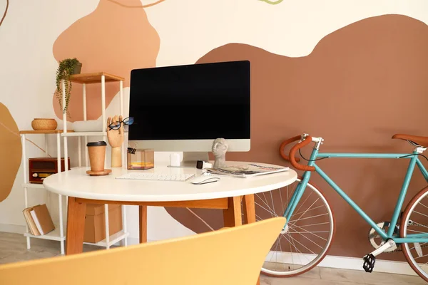 Renkli Duvarın Yanında Modern Bilgisayar Bisiklete Sahip Bir Işyeri — Stok fotoğraf