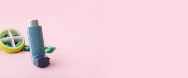 Astım spreyi ve pembe arka planda metinler için yeri olan haplar.