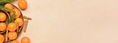 Lezzetli mandalinalı tabaklar ve bej arkaplanda tarçın ve metin için yer var.