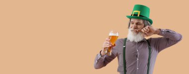 Son sınıf öğrencisi renkli arka planda bira içiyor ve mesaj için yer var. Aziz Patrick Günü kutlaması