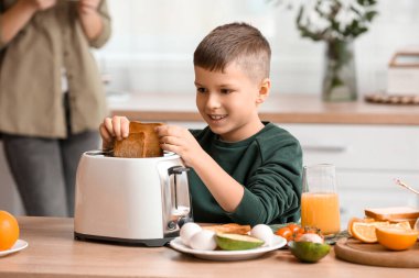 Küçük çocuk mutfakta lezzetli tost yapıyor.