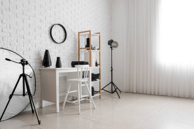 Modern iş yeri ve raf ünitesi fotoğraf stüdyosunun içinde farklı ekipmanlara sahip.