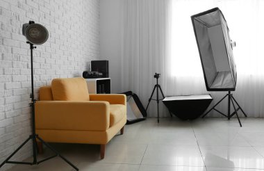 Rahat koltuk ve beyaz tuğla duvarın yanında farklı ekipmanlar.