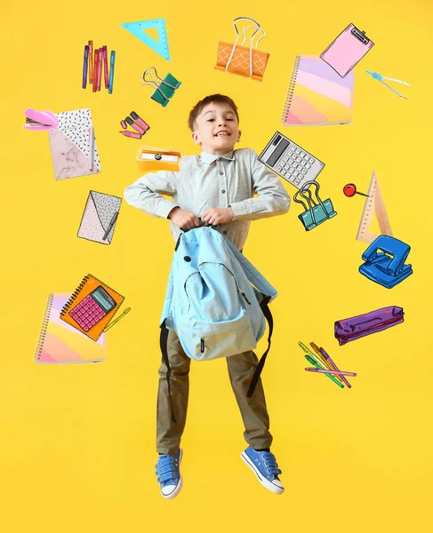 Zıplayan Küçük Okul Çocuğu Sarı Arka Planda Farklı Kırtasiye Malzemeleri — Stok fotoğraf