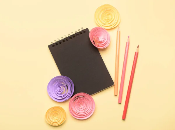 Schwarzes Notizbuch Und Papierblumen Auf Farbigem Hintergrund — Stockfoto