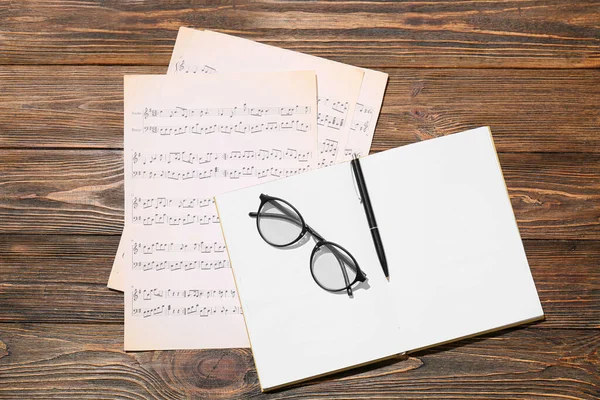 Eyeglasses Music Sheets Notebook Wooden Background — Stock Photo, Image