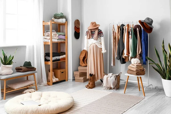 Manken, askılık ve kalın kazaklarla aydınlık soyunma odasının içinde.