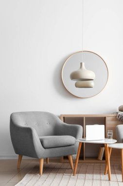 Rahat koltuk ve masa modern dizüstü bilgisayarla şık bir oda içinde.