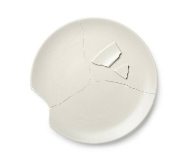 Beyaz zemin üzerinde kırık seramik plaka