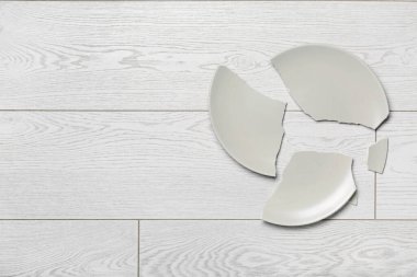 Açık ahşap zemin üzerinde kırık seramik tabak