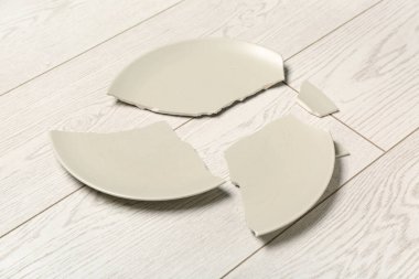 Açık ahşap zemin üzerinde kırık seramik tabak