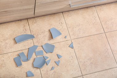 Mutfakta yerde kırık seramik tabak.