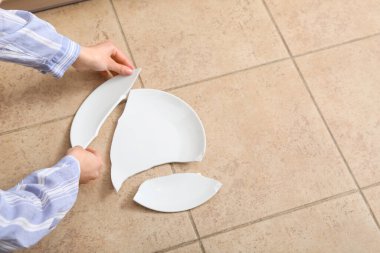 Kırık beyaz tabağı olan kadın elleri.