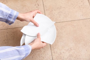 Kırık tabak parçalarıyla kadın elleri.