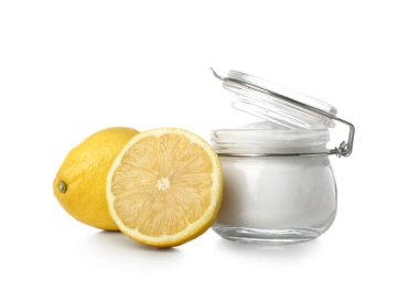 Beyaz arka planda bir kavanoz kabartma tozu ve olgun limon.