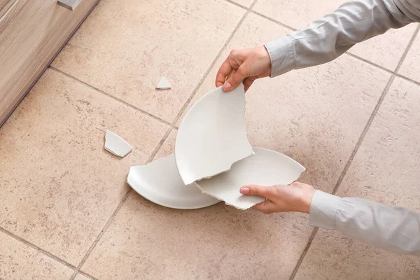 厨房地板上陶瓷板破碎的女性手 — 图库照片