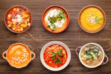 Ahşap arka planda lezzetli çorbalar, üst manzara.