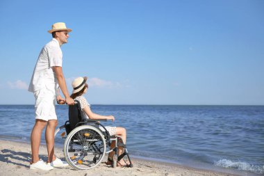 Deniz tatil köyünde fiziksel engelli genç adam ve kız arkadaşı.