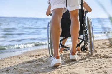 Deniz tatil köyünde fiziksel engelli genç adam ve kız arkadaşı.