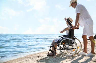 Deniz tatil köyünde fiziksel engelli genç adam ve kız arkadaşı.