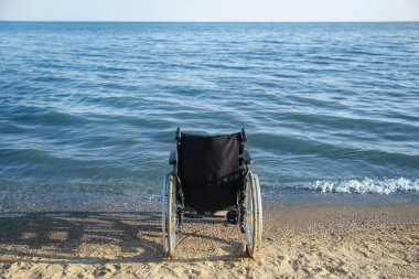 Yaz günü deniz kenarındaki boş tekerlekli sandalye.