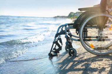 Yaz günü deniz kenarındaki boş tekerlekli sandalye.