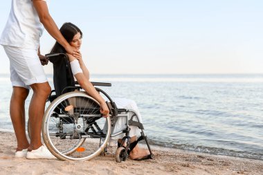 Fiziksel engelli genç bir kadın ve deniz kenarındaki erkek arkadaşı.