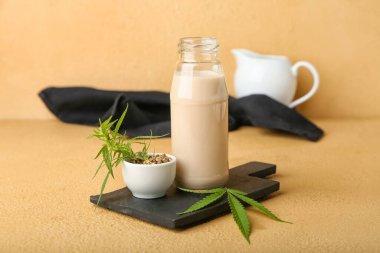 Renkli arka planda sağlıklı kenevir sütü ve tohumları olan tahta