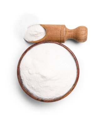 Beyaz arka planda bir kase kabartma tozu ve kepçeyle