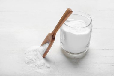Kavanoz ve kaşık beyaz ahşap arka planda kabartma tozu ile
