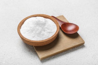 Hafif arka planda kabartma tozu ve kaşıkla kase