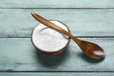 Kabartma tozu ve kaşık renkli ahşap arka planda