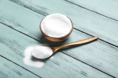 Ahşap arka planda kabartma tozu ile kase ve kaşık