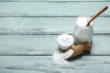 Kavanoz, kase ve kepçe renkli ahşap arka planda kabartma tozu