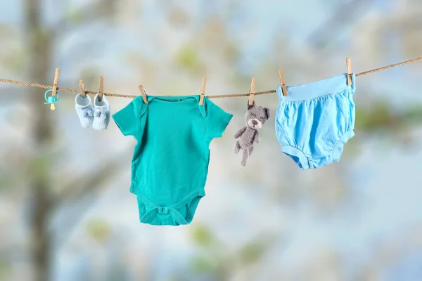 Bebek Kıyafetleri Oyuncak Emzik Dışarıda Asılı Duruyor — Stok fotoğraf