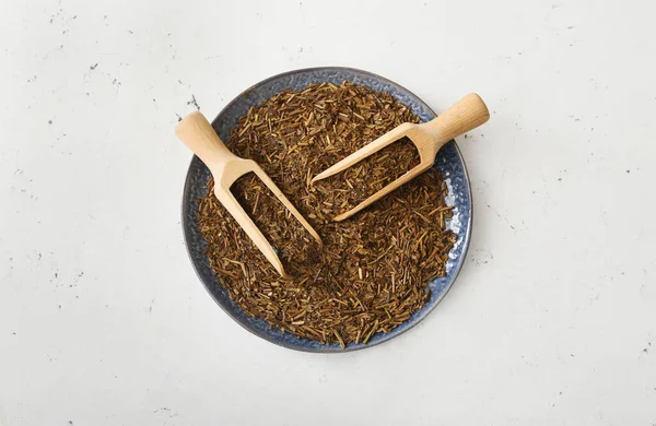 Yeşil hojicha çaylı tabak ve hafif arka planda kepçe