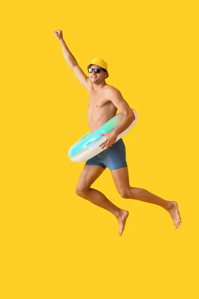 Jumping Young Man Inflatable Ring Yellow Background —  Fotos de Stock