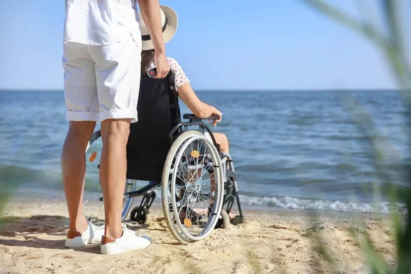 Deniz tatil köyünde fiziksel engelli genç adam ve kız arkadaşı.