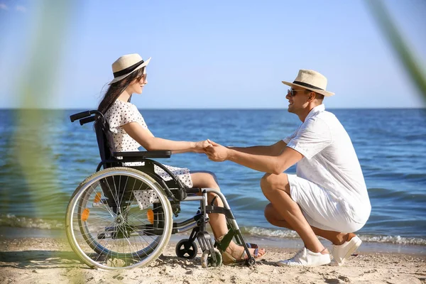 Deniz tatil köyünde fiziksel engelli genç adam ve kız arkadaşı.