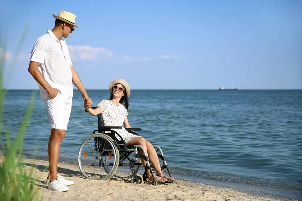 Deniz tatil köyünde fiziksel engelli genç adam ve kız arkadaşı.