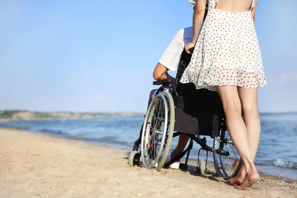 Deniz tatil köyünde fiziksel engelli genç kadın ve erkek arkadaşı.