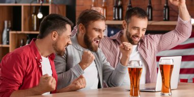 Bardaki spor bahsini kazandıktan sonra mutlu adamlar.