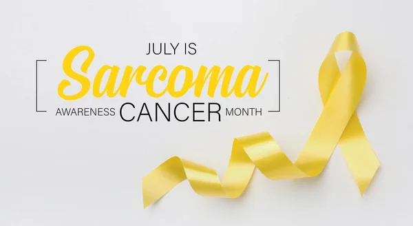 Yellow ribbon and text JULY IS SARCOMA CANCER AWARENESS MONTH on light background