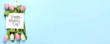 Anneler günü için tebrik kartı ve açık mavi zemin üzerinde güzel laleler.
