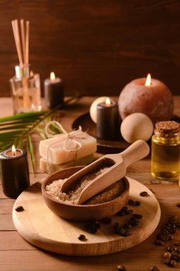 Tahta masada deniz tuzu ve spa aksesuarlarıyla kase.