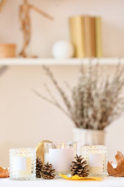Odada sonbahar dekoru olan tutacaklarda mum yakmak.