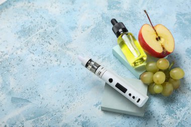Mavi arka planda modern vape mod, yağ ve meyveler
