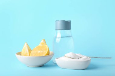 Kabartma tozu, olgun limon ve renkli bir şişe suyla dolu kaseler.