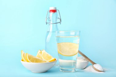 Bir bardak su, limonlu kase ve renkli kabartma tozu.