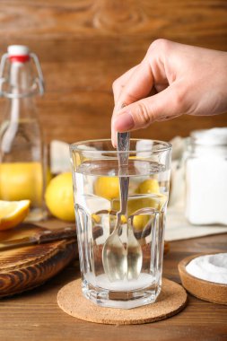 Kadın ahşap zeminde suyu kabartma tozuyla karıştırıyor.